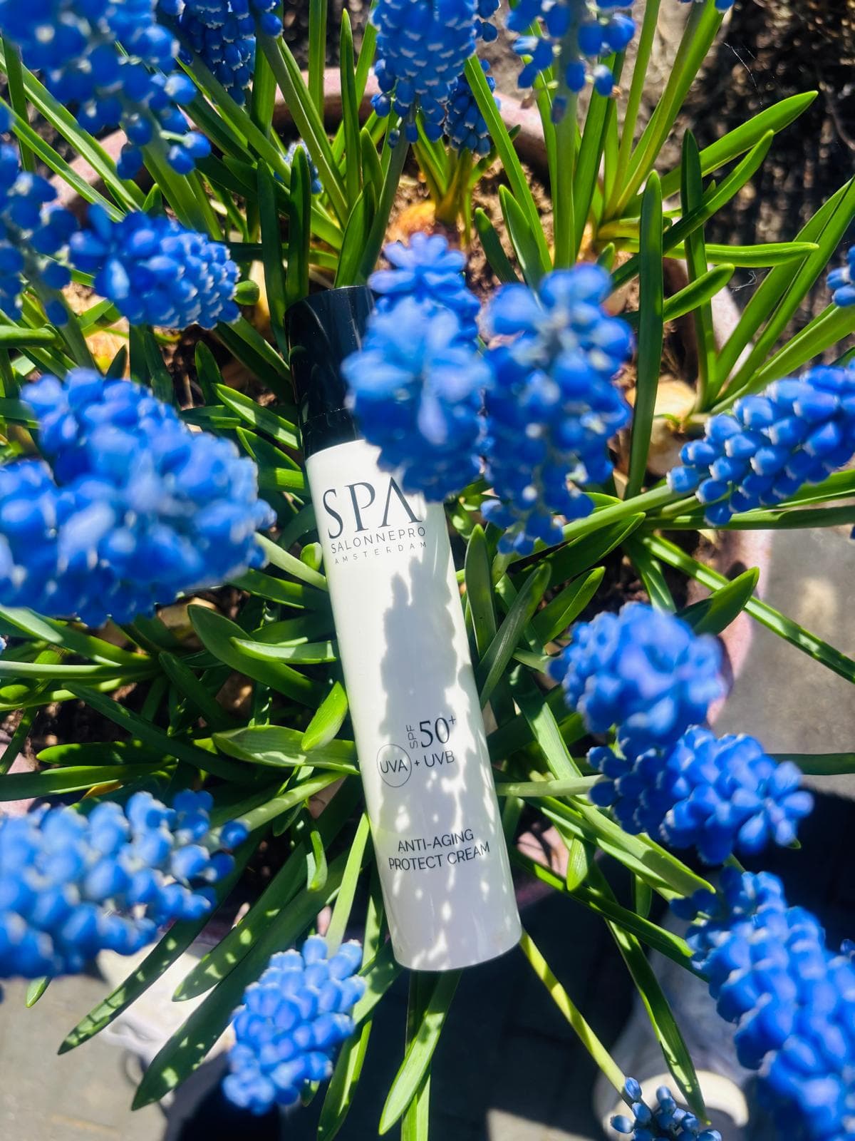 SPA SalonnePro-zonbescherming tussen blauwe bloemen